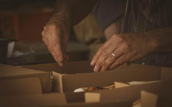 Person opening a box (Unsplash/Jonny Gios)