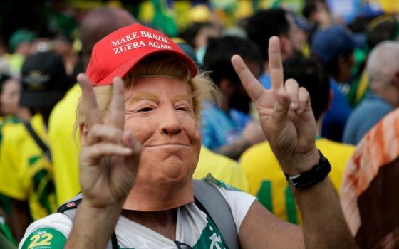 A supporter wears a mask depicting U.S. President Donald Trump during opposition presidential candidate Sen. Flávio Bolsonaro's final campaign rally ahead of Brazil's presidential runoff election in Rio de Janeiro, Brazil, Oct. 24, 2026. (AP/Bruna Prado)