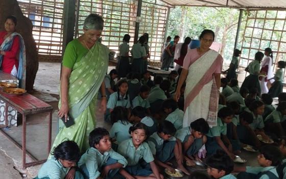 Students of Chirag Vidyalaya in Rajgir, in the eastern Indian state of Bihar, eat lunch in Chetanalaya Hostel Hall, just opposite the school building. Overseeing the lunch distribution are Nazareth Srs. Rose Plathottam (left) and Jyoti Kerketta. (Jose Kalapura)