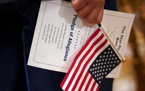 A U.S. flag and a copy of the Pledge of Allegiance are held during a naturalization ceremony in 2021. (OSV News/Reuters/Kevin Lamarque)
