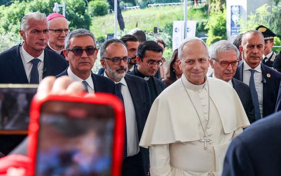 Pope Leo XIV smiles as a person takes a cellphone photo as the pontiff arrives at Rome's Gemelli Hospital Oct. 13, 2026, ahead of his surgery that afternoon. (OSV News/Reuters/Ciro De Luca)