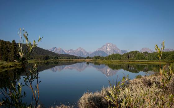 The Teton mountains reflect on Oxbow Bend in Grand Teton National Park in Moran, Wyoming, Aug. 22, 2025. (AP photo/Amber Baesler, File)