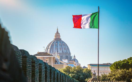 An Italian flag flies in Rome, with the dome of St. Peter's Basilica at the Vatican seen in the background. (Dreamstime/Vchalup)