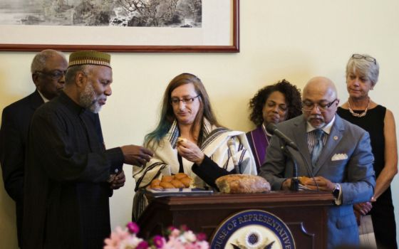 Imam Johari Abdul-Malik shares bread with Rabbi Alana Suskin at an interfaith prayer service in the Cannon House Office Building in Washington, D.C., May 8. (NETWORK Lobby for Catholic Social Justice/Mehreen Karim)