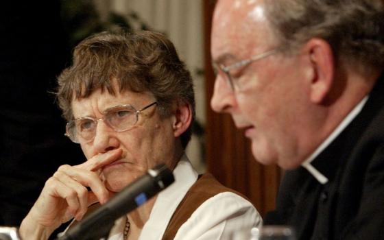 Theologian Monika Hellwig, president and executive director of the Association of Catholic Colleges and Universities, listens to remarks from Richard John Neuhaus, editor of the journal First Things, during a conference in 2004.