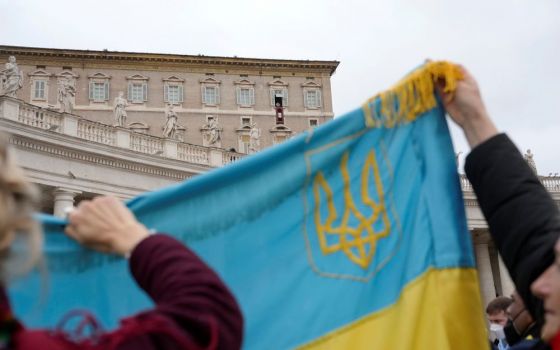 Ukrainian faithful hold their national flag as Pope Francis delivers the Angelus noon prayer from his studio window overlooking St. Peter's Square, at the Vatican, Feb. 20. (AP/Gregorio Borgia)