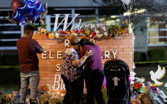 People visit a memorial outside Robb Elementary School in Uvalde, Texas, May 25, the site of a mass shooting. An 18-year-old man shot and killed 19 children and two teachers and injured several more people. (CNS/Reuters/Nuri Vallbona)