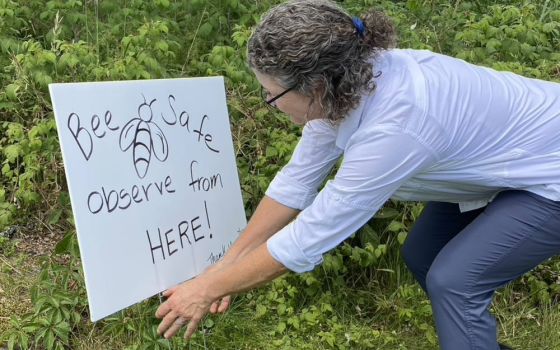 Cindy Thompson adjusts a sign at the Mercy Ecospirituality Center in Benson, Vermont. She and her husband, Chris Thompson, spent six weeks in a Sisters of Mercy program. (Marybeth Redmond)