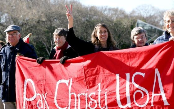 Jean Stoken, a Washington-area resident, flashes a peace sign as members of Pax Christi gather for an anti-war rally on the National Mall in Washington Jan. 27, 2009, calling for an end to the war in Iraq.