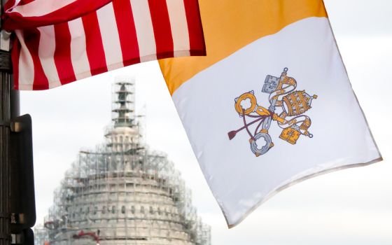 US flag, Vatican flag seen with US capitol dome in background with scaffolding