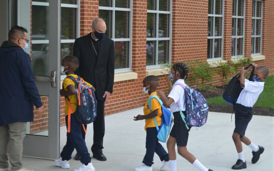 Youngsters enter the first new Catholic school built in Baltimore in roughly 60 years with a mix of enthusiasm and first-day-back jitters, Monday Aug. 30, 2021. (AP Photo/David McFadden)