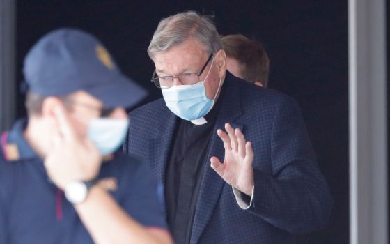 Australian Cardinal George Pell waves as he arrives at Rome's international airport in Fiumicino, Wednesday, Sept. 30, 2020.
