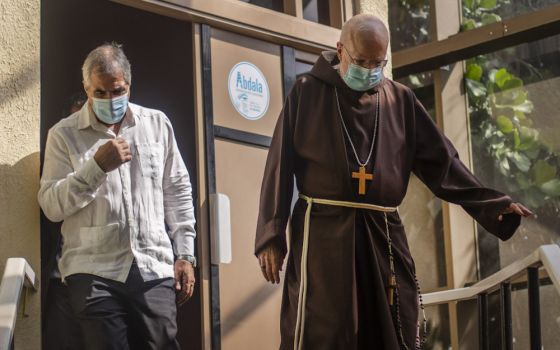 Boston Cardinal Sean O'Malley, right, walks with Eduardo Martínez Díaz, president of BioCubaFarma, as they walk Sept. 9 through Cuba's Genetic Engineering and Biotechnology Center. (AP/Ramon Espinosa)