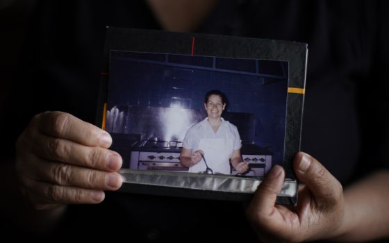 Beatriz Delgado holds an undated photo of herself working in the kitchen of an Opus Dei house, in Buenos Aires, Argentina, Thursday, Nov. 4, 2021. (AP Photo/Victor R. Caivano)
