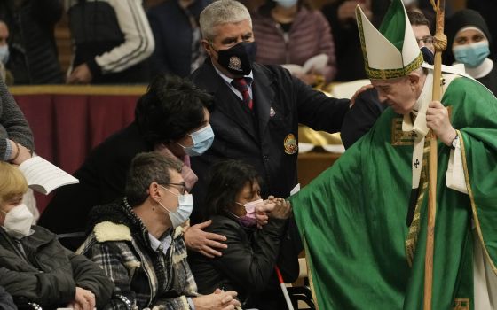 Pope Francis greets faithful at the end of a Mass on the Day of the Poor in St. Peter's Basilica, at the Vatican, Sunday, Nov. 14, 2021. (AP Photo/Gregorio Borgia)