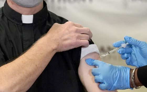 In this Wednesday, Dec. 23, 2020 file photo, a Catholic pastor receives the first of the two Pfizer-BioNTech COVID-19 vaccinations at a hospital in Chicago. In a growing consensus, religious leaders at the forefront of the anti-abortion movement in the Un