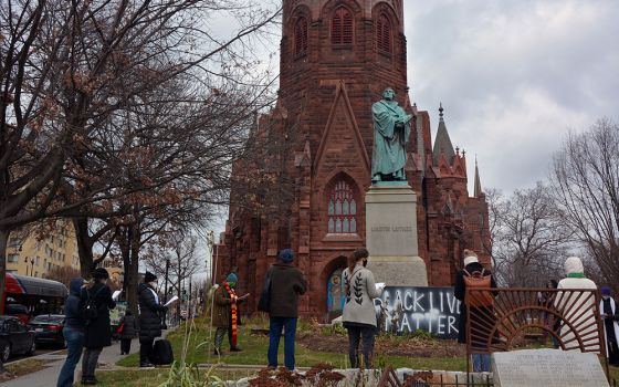 An interfaith group of religious leaders prays outside of Luther Place Memorial Church on Jan 6 in Washington. (RNS/Jack Jenkins)