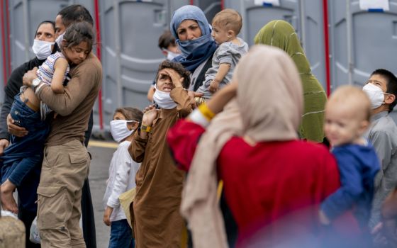 People evacuated from Afghanistan step off a bus as they arrive at a processing center Aug. 23 in Chantilly, after arriving on a flight at Dulles International Airport. (AP/Andrew Harnik)