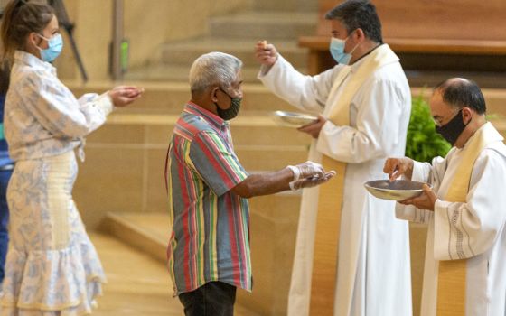 The faithful wear masks and some wear gloves as they receive Communion at the first English Mass with faithful present at the Cathedral of Our Lady of the Angels June 7, 2020, in downtown Los Angeles. (AP/Damian Dovarganes)