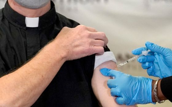 A Catholic pastor receives the first of the two Pfizer-BioNTech COVID-19 vaccinations at a hospital in Chicago, Dec. 23, 2020. (AP/Charles Rex Arbogast)