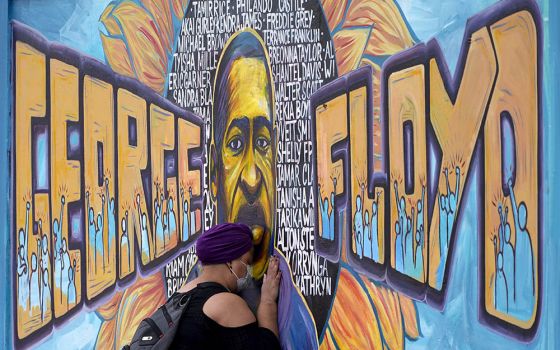 Damarra Atkins pays her respects to George Floyd at a mural at George Floyd Square April 23 in Minneapolis. (AP Photo/Julio Cortez)