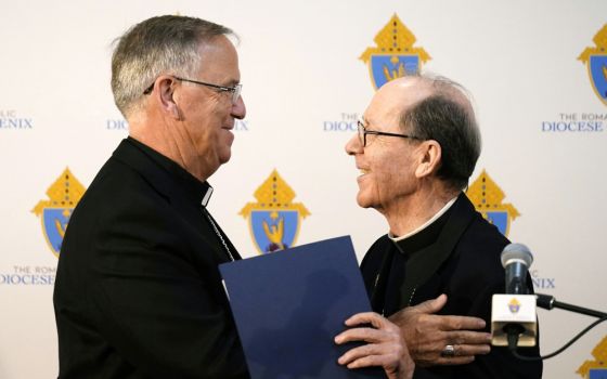 Bishop John Dolan, left, smiles along with retiring Bishop Thomas Olmsted as Dolan is introduced at a news conference after being named the new bishop for the Roman Catholic Diocese of Phoenix June 10 in Phoenix. (AP/Ross D. Franklin)