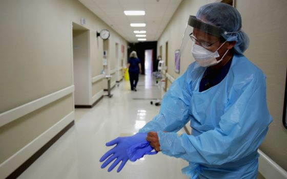 Registered nurse Kevin Hoover puts on protective gear as he prepares to check on a COVID-19 patient May 20 at the rural 24-bed Kearny County Hospital in Lakin, Kansas. The county has seen a spike in cases due to clusters in nearby meatpacking plants. (AP)