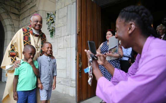 Archbishop Wilton Gregory poses with two boys after celebrating Mass at St. Augustine Church in Washington, D.C., June 2. (CNS/Catholic Standard/Andrew Biraj)
