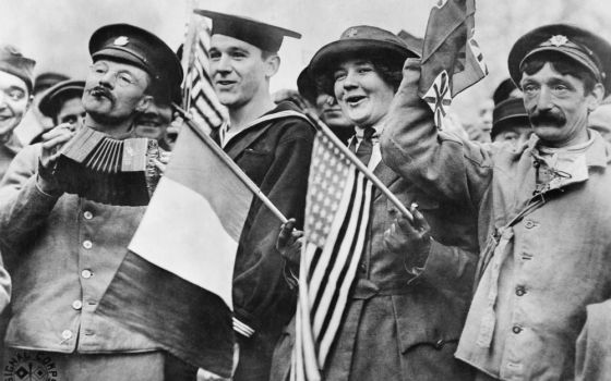 An American sailor, an American Red Cross nurse and two British soldiers celebrate the signing of the Armistice, near the Paris Gate at Vincennes, France, Nov. 11, 1918. (Wikimedia Commons/Imperial War Museum)