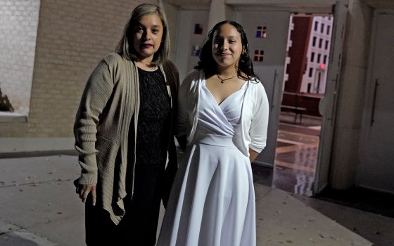 Parishioners Eliana Najera and her daughter, Alysson Najera, 13, stop for a photograph as they leave St. Gregory Catholic Church, Phoenix, AZ , Feb. 24, 2022. (AP Photo/Matt York)