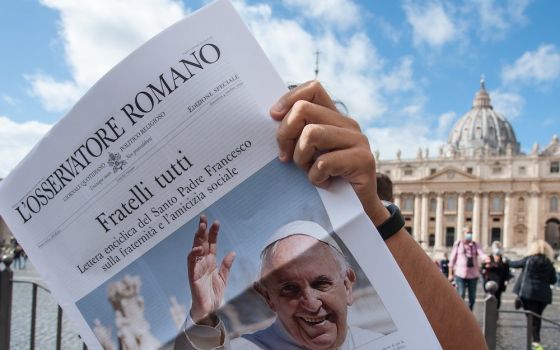Free copies of the Vatican newspaper L'Osservatore Romano with the front page about Pope Francis' encyclical, " 'Fratelli Tutti,' on Fraternity and Social Friendship," are distributed by volunteers at the end of the Angelus in St. Peter's Square at the Va