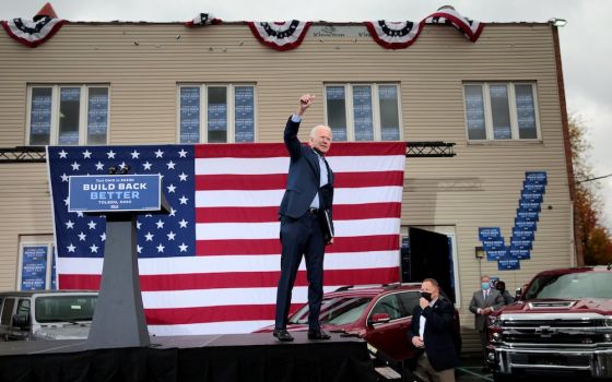 Democratic presidential nominee Joe Biden raises his arm during a drive-in campaign event in Toledo, Ohio, Oct. 12. (CNS//Reuters/Rebecca Cook)