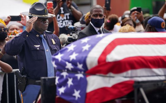 An Alabama State Trooper salutes the casket carrying the late Rep. John Lewis, D-Ga., after it was carried across the Edmund Pettus Bridge in a horse-drawn carriage in Selma, Alabama, July 26. The civil rights movement legend who was a colleague of the Re