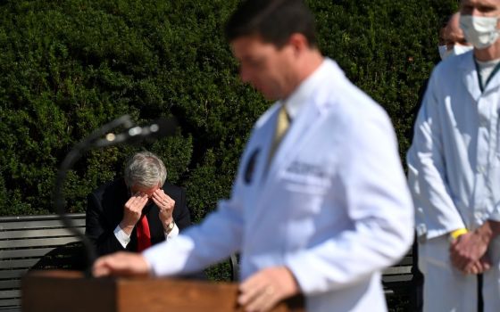 White House Chief of Staff Mark Meadows, left, sits outside Walter Reed National Military Medical Center in Bethesda, Maryland, Oct. 4, as Dr. Sean Conley, a Navy commander who is the White House physician, speaks to the media about President Donald Trump