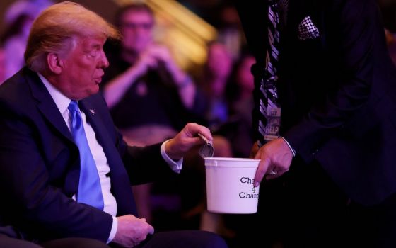 President Donald Trump donates money during a worship service at the International Church of Las Vegas in Las Vegas Oct. 18. (CNS/Reuters/Carlos Barria)
