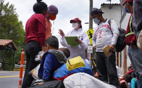 Humanitarian worker Angie Rincon speaks with Venezuelan migrants in early October 2020, at the entrance to Pamplona, Colombia. Rincon is leading a project for migrants funded by Caritas France. (CNS/Manuel Rueda)