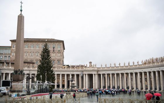 People gather as Pope Francis leads the Angelus from the window of his studio overlooking St. Peter's Square at the Vatican Dec. 6. No pandemic and no kind of crisis can extinguish the light of Christ, the pope said. (CNS/Vatican Media)