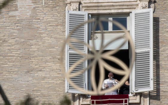 Pope Francis is pictured through an ornament on the Christmas tree as he leads the Angelus from the window of his studio overlooking St. Peter's Square at the Vatican Dec. 20. (CNS/Vatican Media)