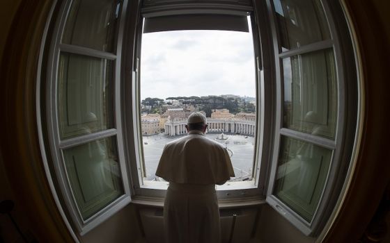Standing in the window of the library of the Apostolic Palace overlooking an empty St. Peter's Square, March 29, Pope Francis blesses the city of Rome, which was under lockdown to prevent the spread of the coronavirus. (CNS/Vatican Media)