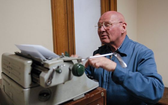 Known for his homework sheets created on a manual typewriter, Discalced Carmelite Fr. Reginald Foster is seen working in his Vatican office in January 2007. He died Dec. 25, 2020, in Milwaukee, Wisconsin, at age 81. (CNS/Chris Warde-Jones)