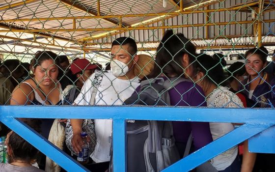 Migrants from Central America seeking asylum in the U.S. are pictured through a fence in Nuevo Teapa, Mexico, Jan. 21, 2021. (CNS/Reuters/Tamara Corro)