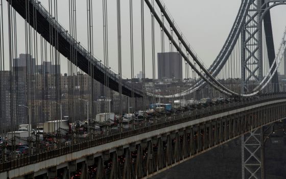 Large bridge viewed from above and side, full of cars