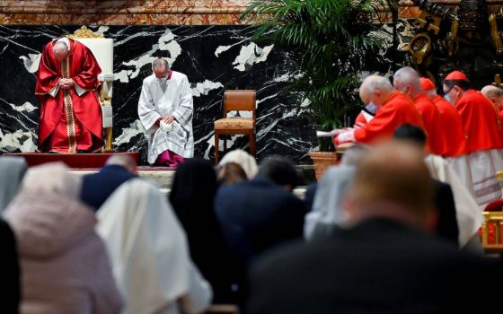 Pope Francis, left, prays as he leads the Good Friday Liturgy of the Lord's Passion April 2, 2020, at the Altar of the Chair in St. Peter's Basilica at the Vatican. (CNS/Reuters pool/Andreas Solaro)