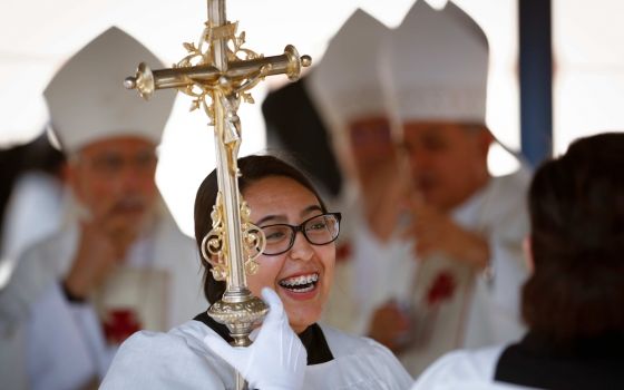 Glenda Lopez smiles as she and other altar servers wait for the start of Mass at the international border in Nogales, Arizona, Oct. 23, 2016. The pope recently changed Vatican law to allow all "lay persons," not just men, to be formally installed as lecto