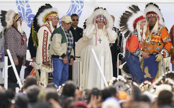 Pope Francis dons a headdress during a visit with Indigenous peoples at Maskwaci, the former Ermineskin Residential School, Monday, July 25, 2022, in Maskwacis, Alberta. (AP Photo/Eric Gay)