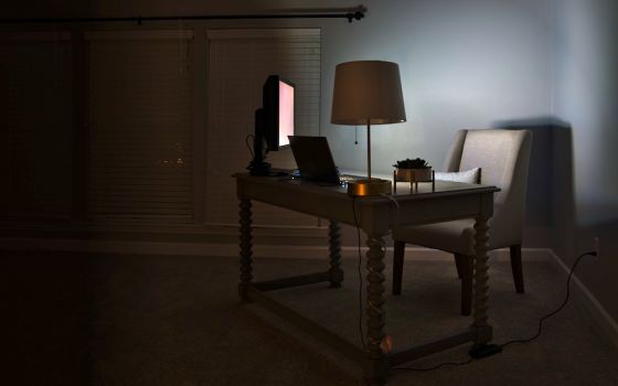 Photograph of a dimly lit room with desk and computer.