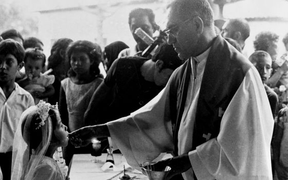 Archbishop Óscar Romero distributes Communion during a confirmation Mass in Ateos, El Salvador, in September 1979. (NCR photo/June Carolyn Erlick)