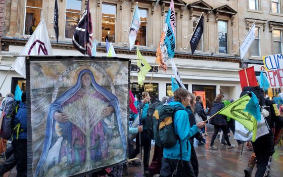 A banner showing Mary embracing a tree is seen in the procession of "climate pilgrims" arriving in Glasgow, Scotland, for the U.N. climate conference known as COP26. (NCR/Brian Roewe) 