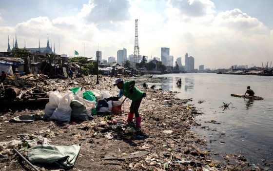 A volunteer member of River Warriors cleans up trash on the banks of the heavily polluted Pasig River in Manila, Philippines. Bishop Noel Pedregosa, new leader of the Malaybalay Diocese in southern Philippines, said he plans to emphasize environment-focus