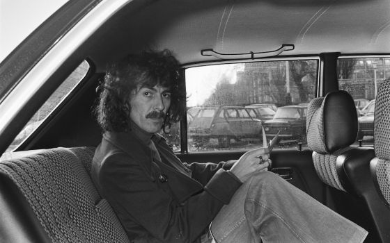 George Harrison is pictured in the back seat of a car as he leaves the Hilton hotel in Amsterdam, the Netherlands, Feb 4, 1977. (National Archives, Anefo collection/Suyk, Koen)